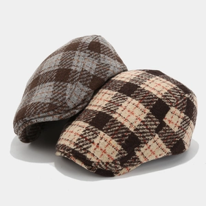 Close-up of vintage plaid beret caps in tweed fabric showing weave texture and colors