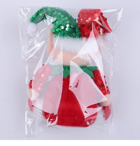 Close-up of a Christmas elf doll with sequin hat in transparent plastic packaging