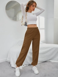 Pantaloni jogger marroni a vita alta con tasche in un moderno ambiente da studio lifestyle