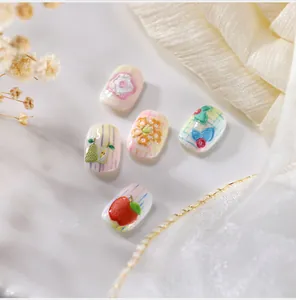 Dettaglio macro di adesivi per unghie 3D a rilievo con motivi di frutta e fiori