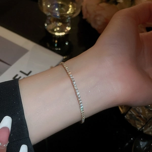 Close-up of a delicate single-row tennis bracelet with sparkling stones on a wrist