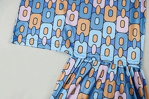 Detailed close-up of retro geometric pattern and precision stitching on the dress fabric