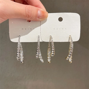 Detail view of gold and silver tassel earrings with micro-pave crystal rhinestones