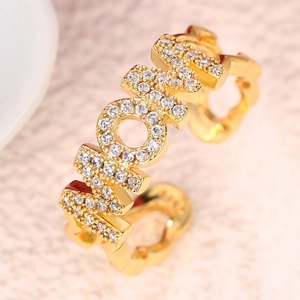 Close-up of gold MOM ring with cubic zirconia paving and heart-shaped hollow band