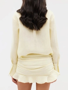 Rear view of pale yellow shirt and ruffled skirt in natural linen texture fabric