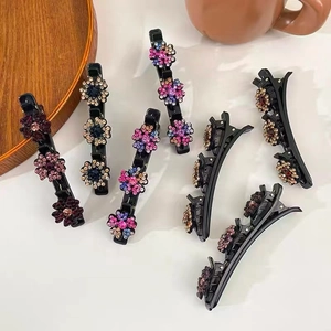 Dettaglio di sei fermagli per capelli neri con fiori di strass scintillanti