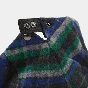Detail of colorful plaid wool newsboy hat with black leather strap and metal button