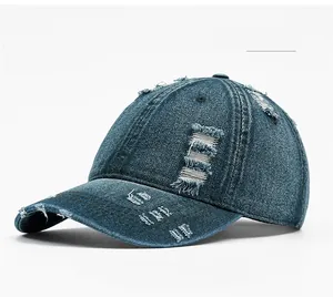Detailed view of the distressed edges and worn denim texture on a dark blue baseball cap