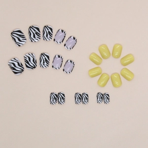 Short oval press-on nails featuring yellow finish and zebra print patterns for women