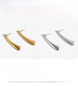 Detailed view of long curved geometric earrings in polished gold and silver finish