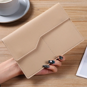 Close-up of beige leather passport holder with V-shaped flap and neat stitching