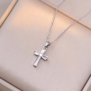 Silver cross necklace with square-cut clear crystals on beige jewelry box display