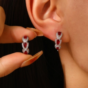 Close-up of triple pear-shaped red zircon drop earrings in silver with fine detailing