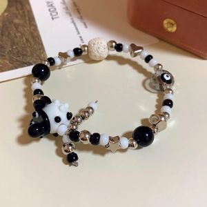 Detailed close-up of rainbow beaded bracelet with panda charm and silver star accents
