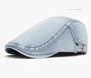 Close-up of light blue washed denim flat cap with bronze buckle and double stitching
