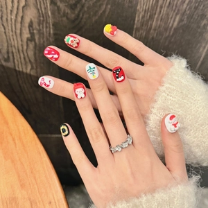 Short round 3D Christmas press-on nails with Santa and reindeer motifs on model hand