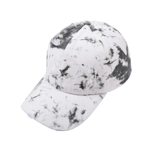 Detailed close-up of distressed black and white tie-dye baseball cap with ripped fabric