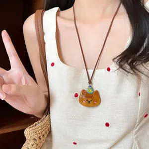 Collana con ciondolo a orsetto carino e cappello colorato indossata da una modella
