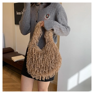 Detail view of a fluffy khaki faux fur handbag with long tassels and soft plush texture