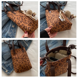 Detail of trendy leopard print handbag with plush charm and secure magnetic closure