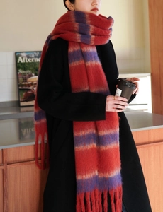 Close-up of thick red and purple striped scarf with fringe tassels and loop yarn texture