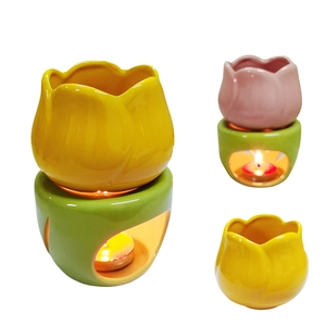 Detail view of tulip shaped ceramic oil burner in yellow and pink with green base