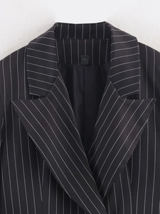Detail of classic black striped blazer showing lapel collar and sharp shoulder cut