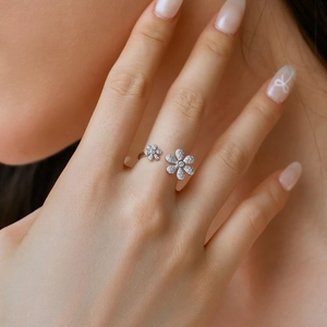 Detail shot of a silver adjustable flower ring with shimmering zircon stones on a finger