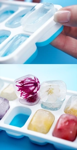 Detail showing ice cube removal from a 14-grid silicone mold with floral ice cubes