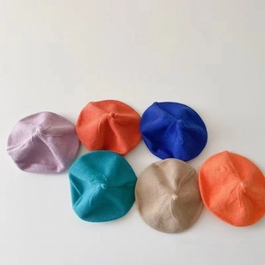 Mise à plat de bérets tricotés colorés pour enfants en violet, bleu et tons orange