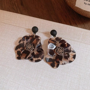 Detailed view of retro leopard print resin flower earrings with metal rose center