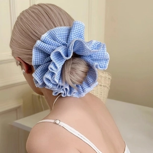 Blue gingham oversized scrunchie accessory worn on a stylish bun hairstyle