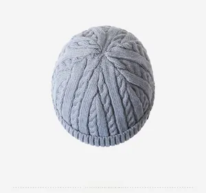 Top-down view of a grey cable-knit winter beanie showing thick ribbed texture and stitches