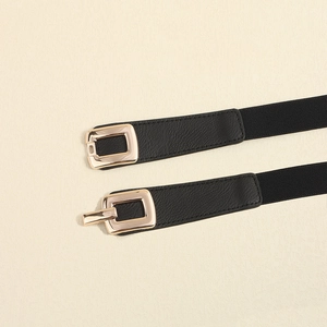 Detail of black elastic waist belt for women with elegant golden rectangular metal buckle