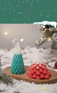 Close-up of green and red gradient Christmas tree candles with leaf texture details