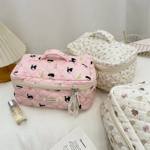 Detailed view of three quilted cartoon makeup bags with cat, flower, and bear patterns