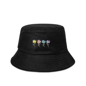 Détail de quatre fleurs brodées colorées sur un chapeau bob en coton noir à large bord