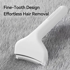 White ergonomic pet de-shedding brush for removing loose fur on a grey pet hair background