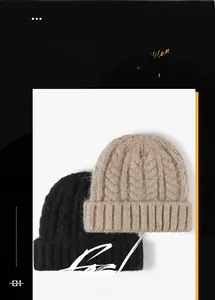 Close-up of cable knit patterns on black and beige winter beanies with thick fold-over cuffs