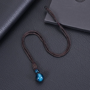 Detailed view of 16mm blue tiger eye stone pendant with hand-woven brown cord necklace