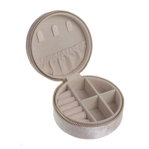 Macro detail of round velvet jewelry box with ring slots and golden zipper closure