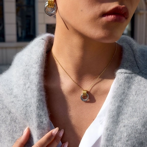 Minimalist interlocking gold and silver circle necklace and earrings on a model