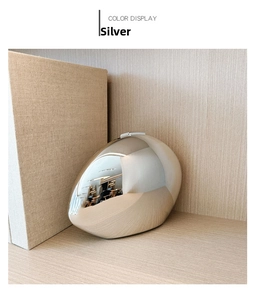 Detailed view of silver oval acrylic clutch bag with a high-shine mirror finish