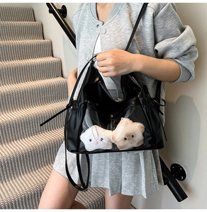 Detail of black tote bag with transparent PVC window and plush star decorations