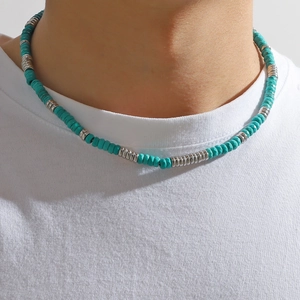 Close-up of bohemian beaded necklace with turquoise stones and silver rings on model