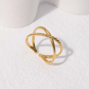 Detailed close-up of golden criss-cross adjustable ring with polished metallic finish