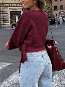 Detail of burgundy long sleeve knit top with crisscross back ribbon and tie-up design
