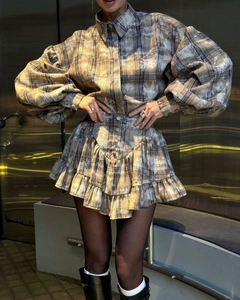 Detail of vintage plaid set featuring puff sleeves and ruffled hem on a textured skirt