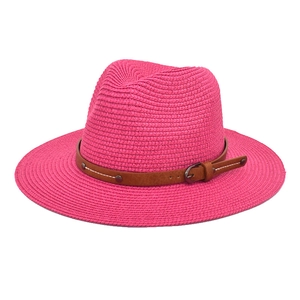 Elegant fuchsia straw Panama hat with brown leather belt accent on a clean background