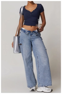 Detail of slim-fit navy blue V-neck t-shirt paired with ripped straight-leg jeans